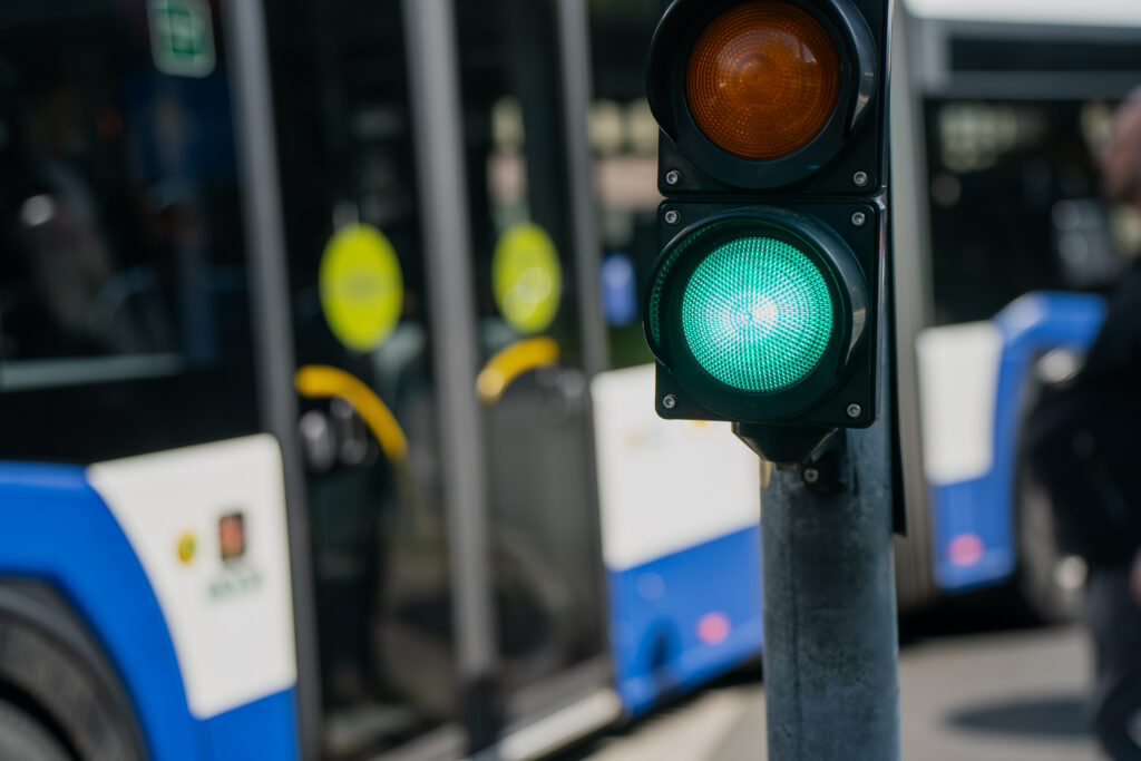traffic signal with green light and city bus behind it.
